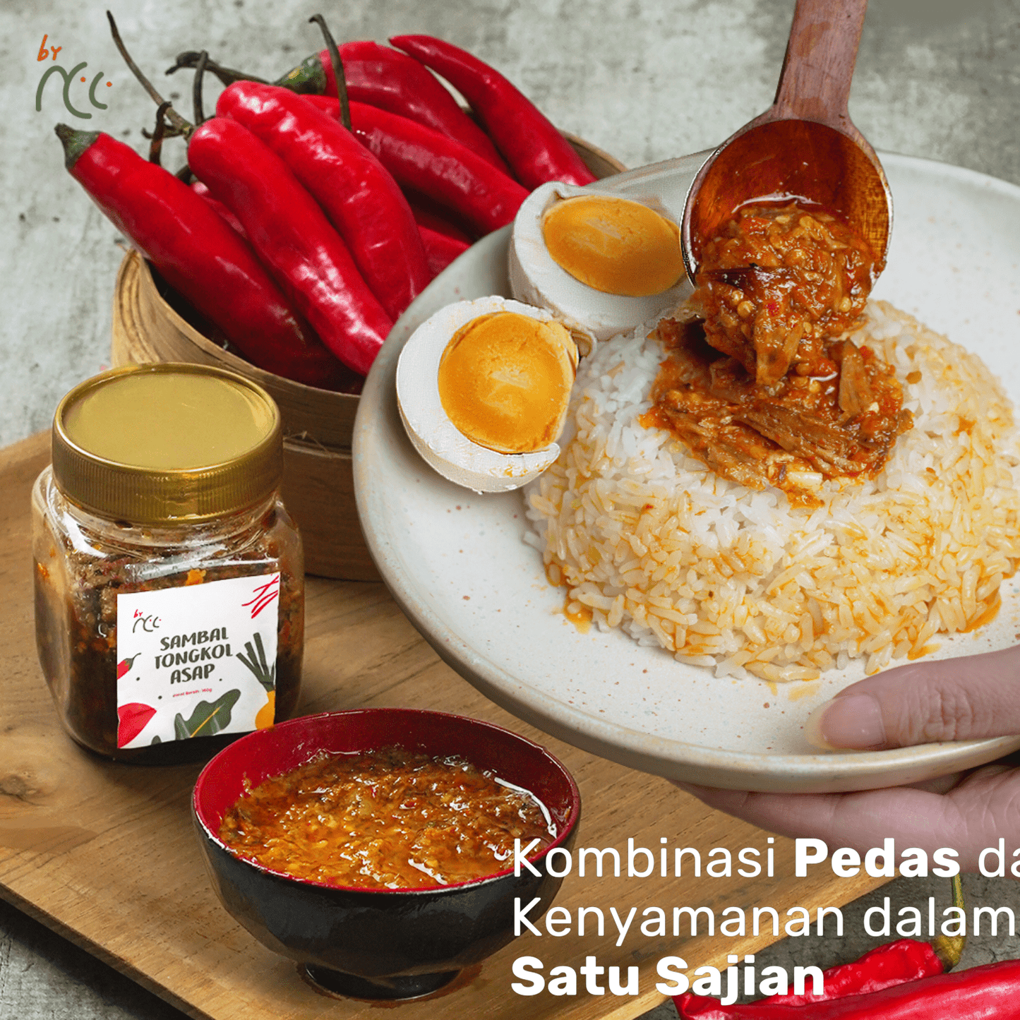 By NCC Sambal Tongkol Asap Pedas Gurih served with rice, boiled eggs, and fresh red chilies in a jar and bowl