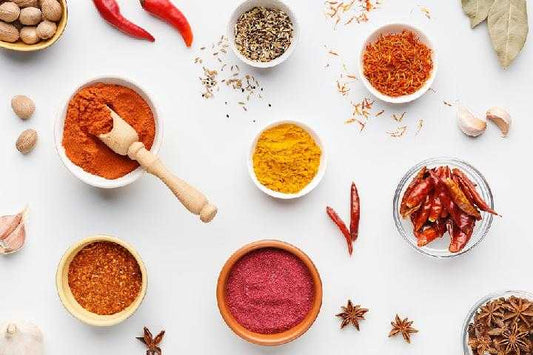 Various traditional Indonesian bumbu dasar spices and ingredients arranged on a wooden surface